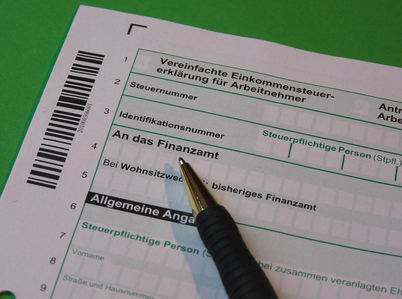 Ausgefülltes Steuerformular mit Kugelschreiber auf grünem Untergrund