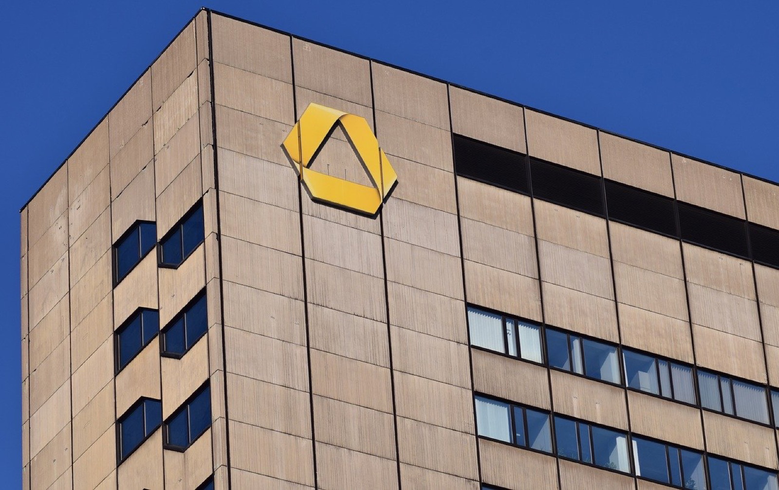 Commerzbank-Logo an einer Hochhausfassade vor blauem Himmel